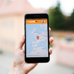 Human hand holding mobile phone with map gps navigation on screen