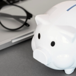 Piggy bank next to laptop
