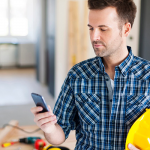 Construction worker with contemporary mobile phone