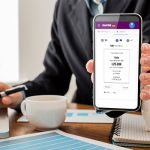 Front view of businessman at the office holding blank smartphone
